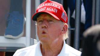 Donald Trump wears a white polo and a Make America Great Again hat | Rich Graessle/Icon Sportswire/Newscom