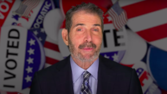 John Stossel in front of "I Voted" buttons | Stossel TV